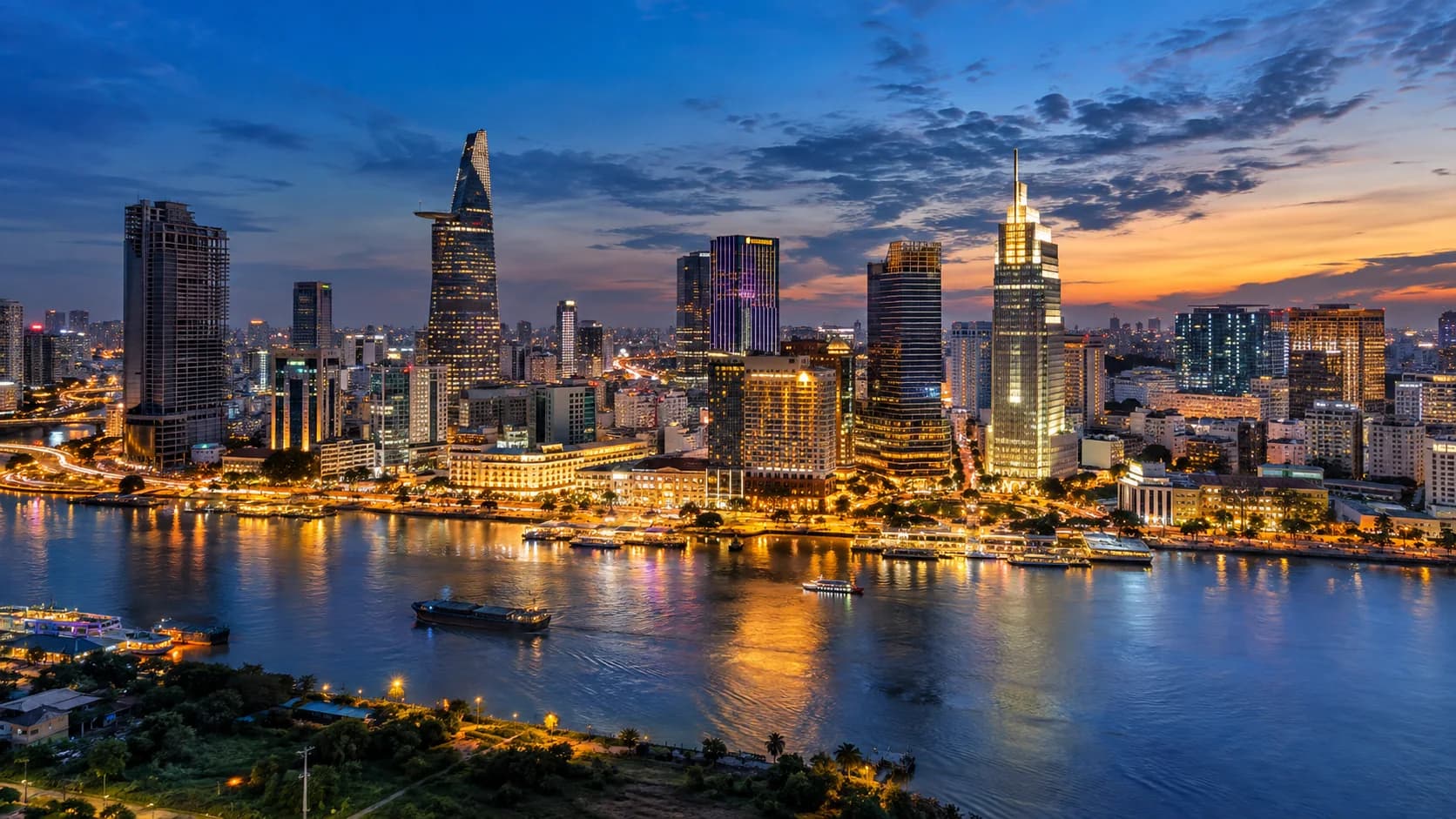 Ho Chi Minh City skyline and river at blue hour with warm illuminated buildings